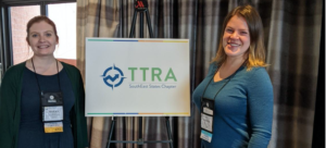 Student, Professor posing in front of TTRA Southeast Chapter sign at conference