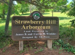 Wooden sign with Strawberry Hill Arboretum printed